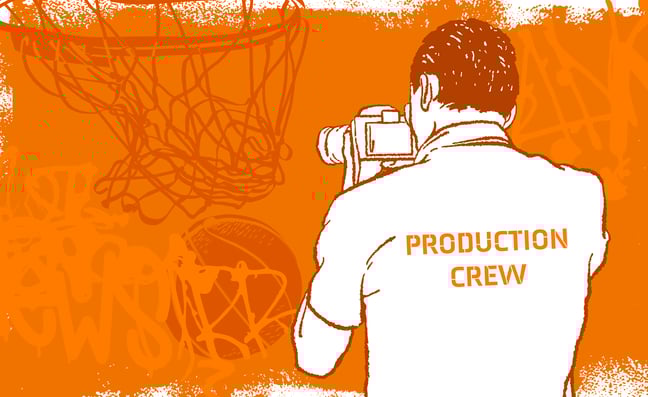 Man with "Production Crew" t shirt holding a camera