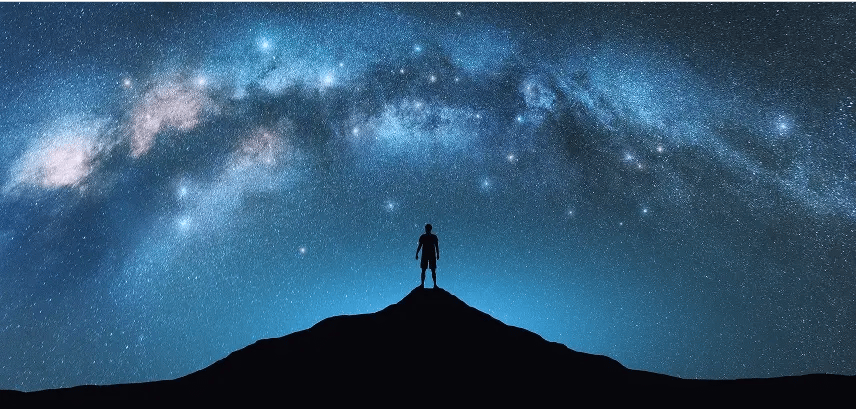 man on mountain looking at sky